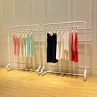 The Men's And Women's Wear In Clothing Shop White Matte Paint Island Shelf Against The Wall