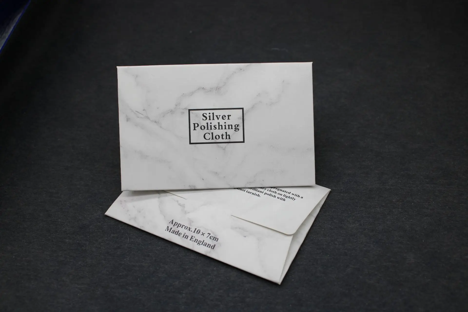 Effective tarnish removal with jewelry cleaning cloth Blue microfiber sterling silver care cloth demonstrating cleaning action