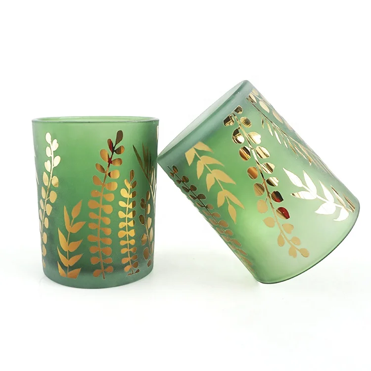 Green candle holder jar with gold leaf motif. 