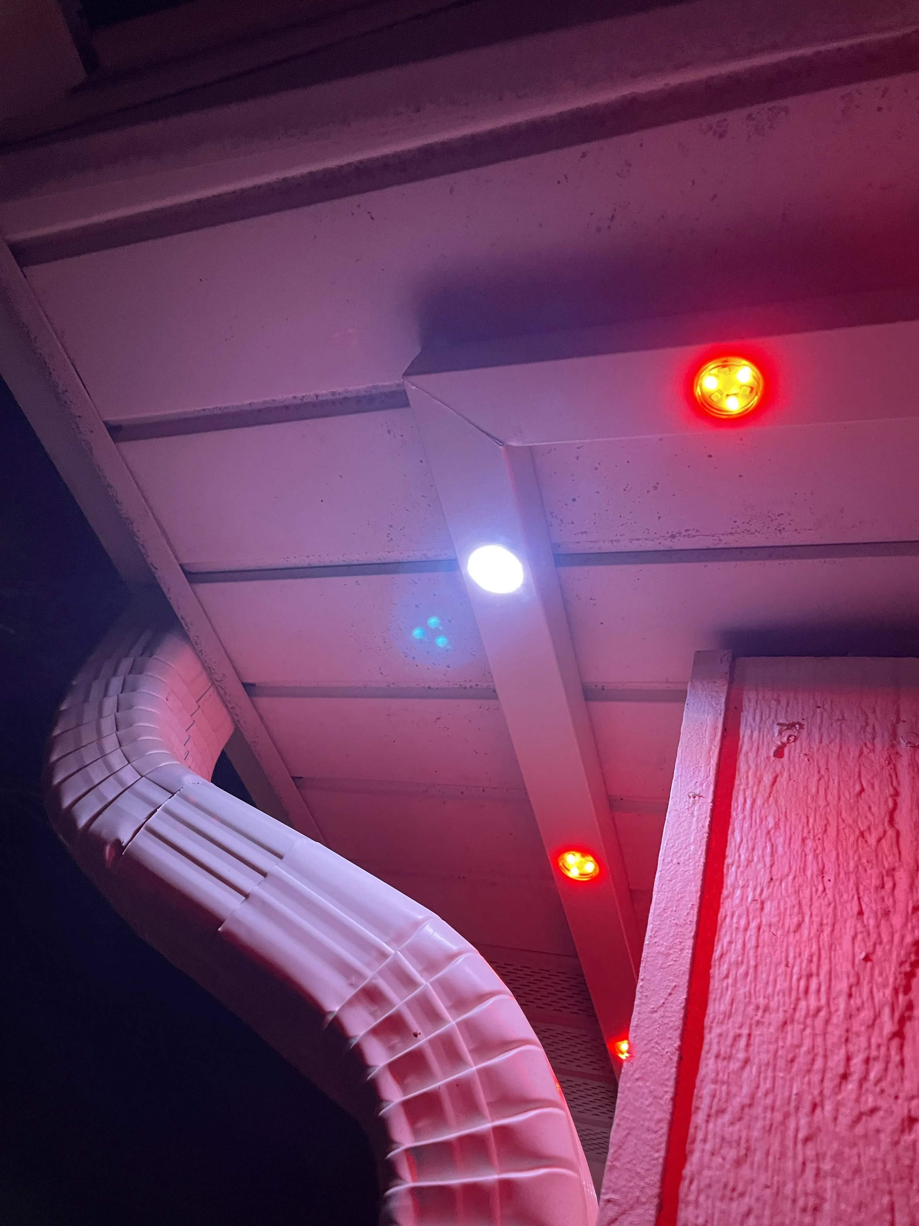 Close-up of installed EverGlow LED lights on house eave glowing in red and blue