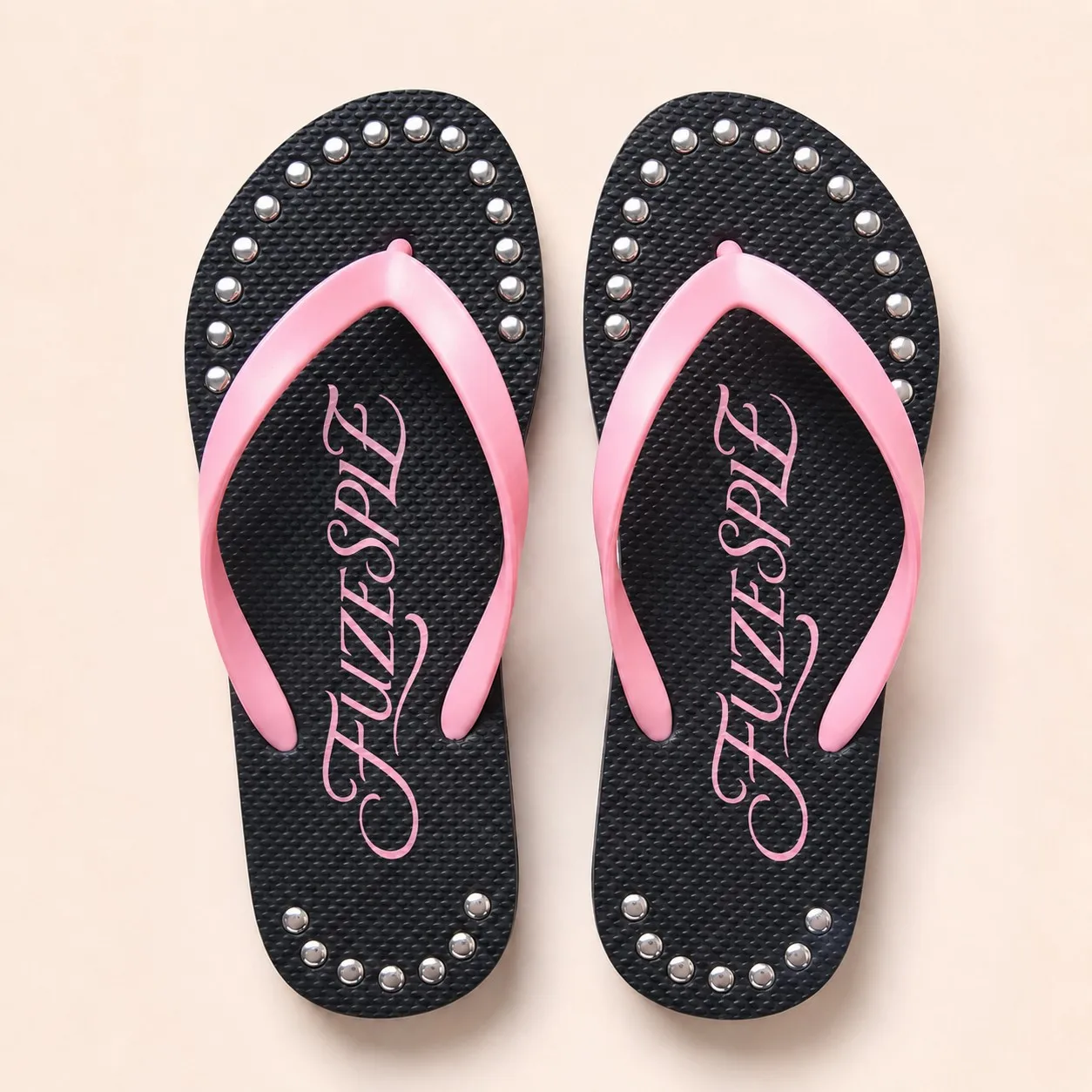 Top view of black and pink studded PE and rubber flip flops