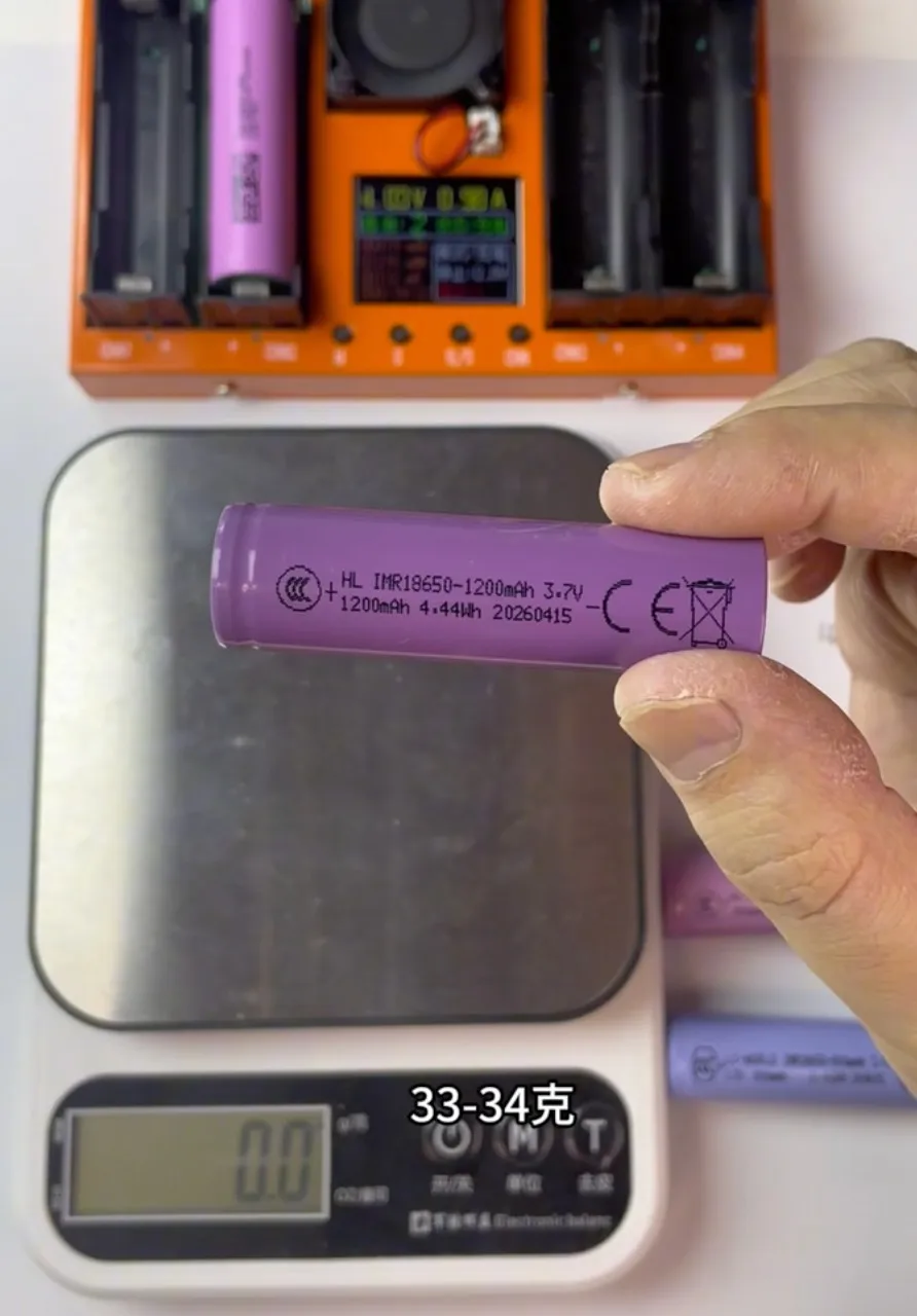 1200mAh 18650 battery sample measuring 33.4g on a digital scale.