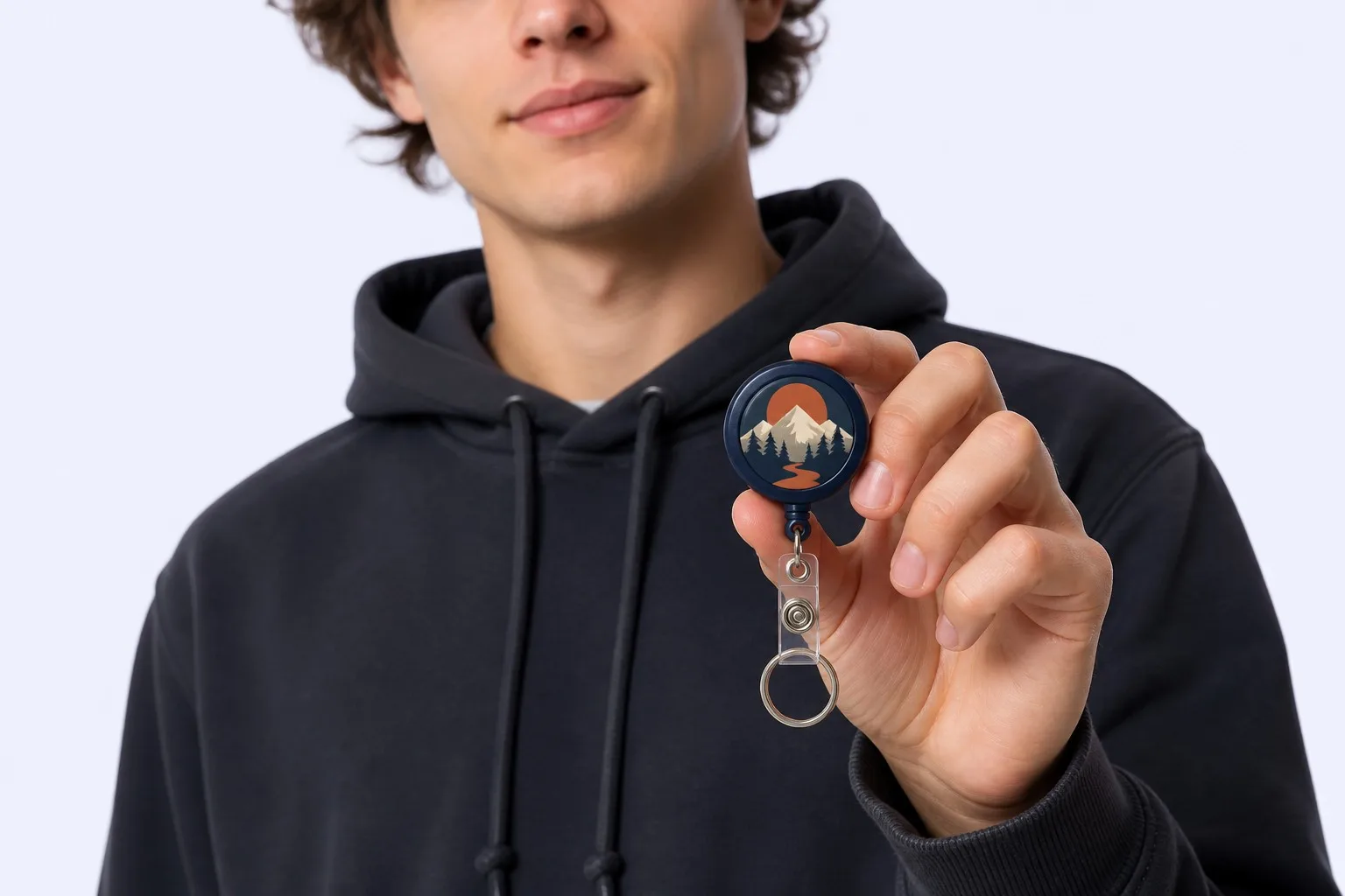 Young man holding badge reel keychain in hand
