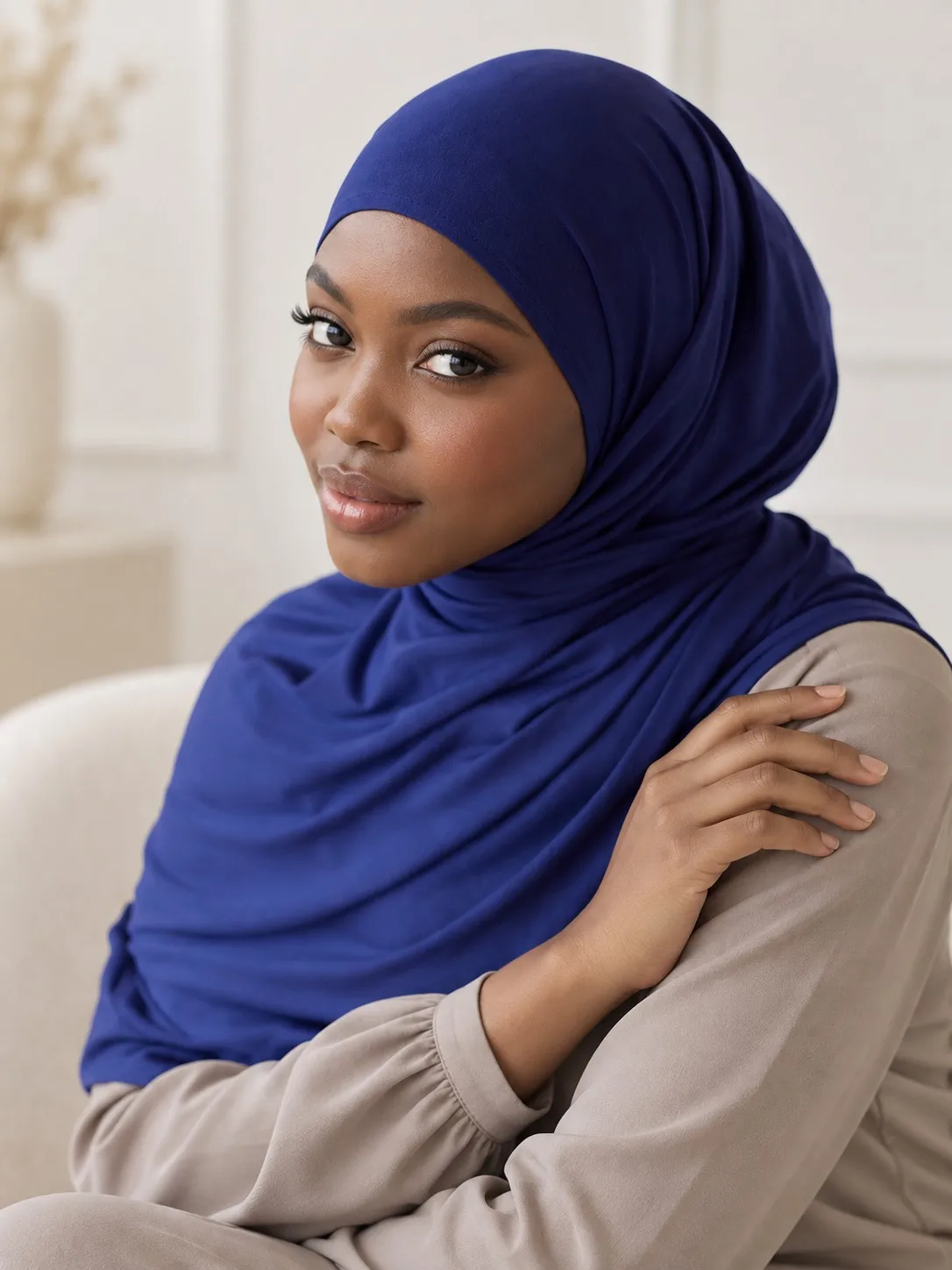 Cotton jersey hijab manufacturer — model seated three-quarter view showing shoulder coverage and fabric fall