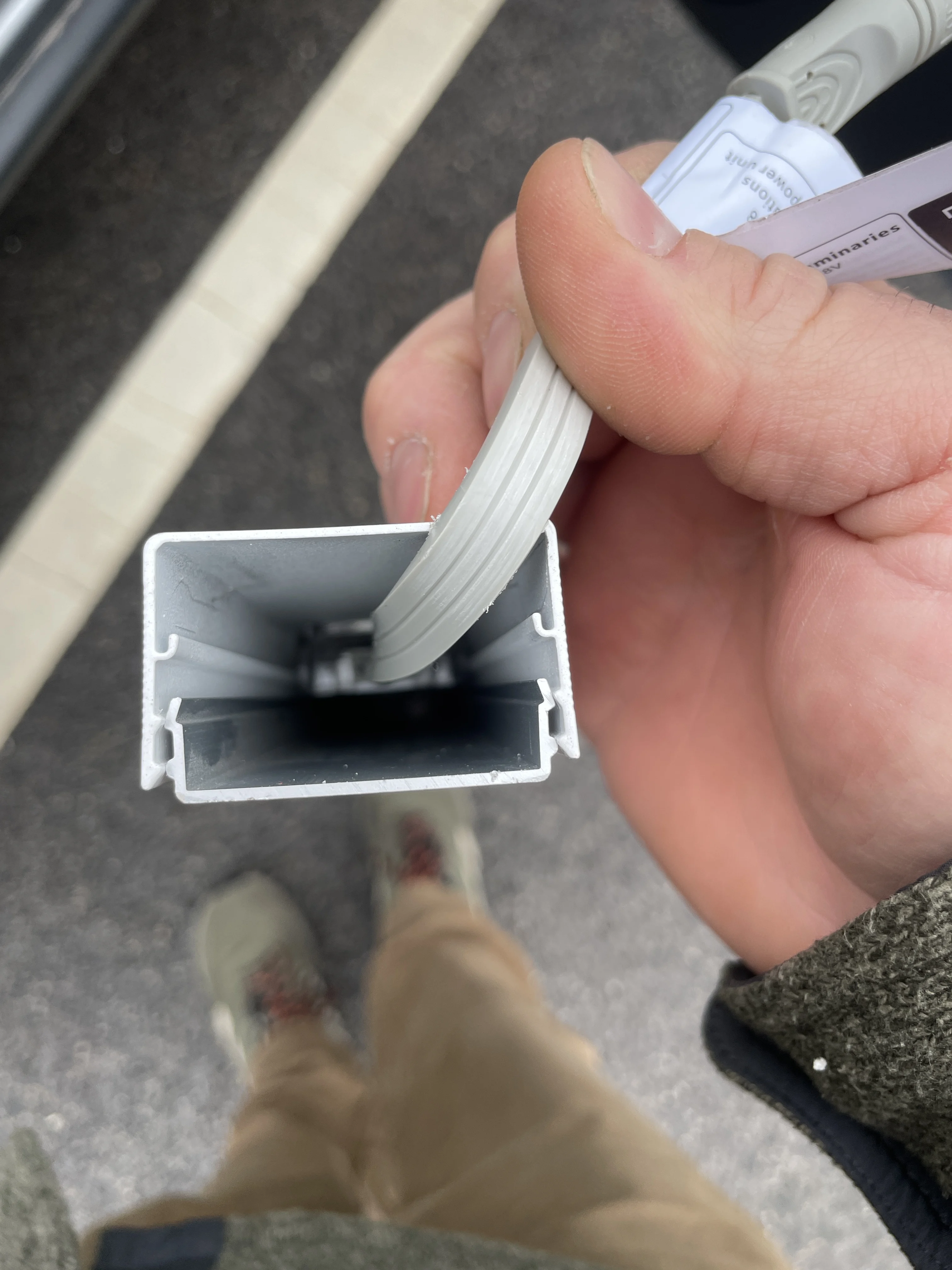 Hand holding white aluminum track for EverGlow LED lights installation
