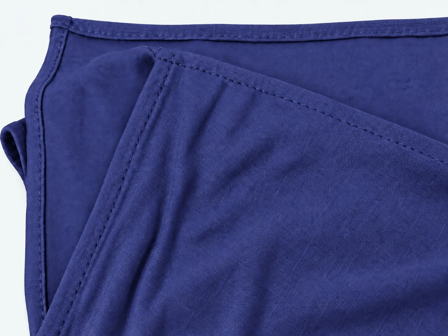 Custom cotton jersey hijab — flat-lay fold detail showing lockstitch hem and cotton knit structure