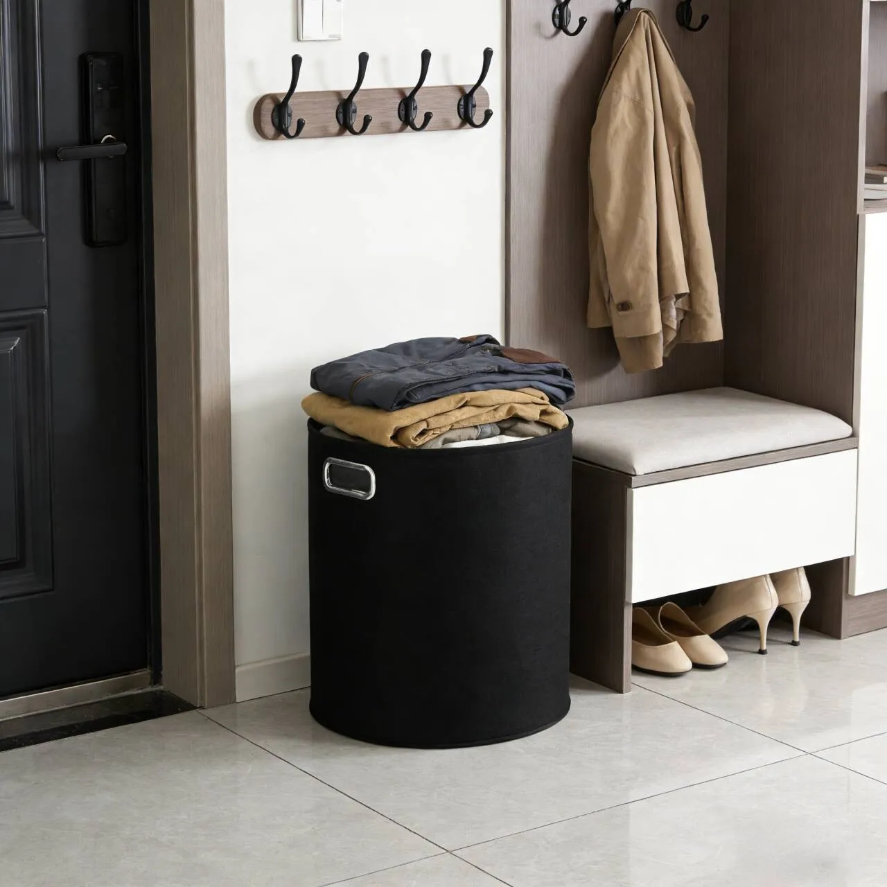 Felt laundry hamper in an entryway with folded clothes