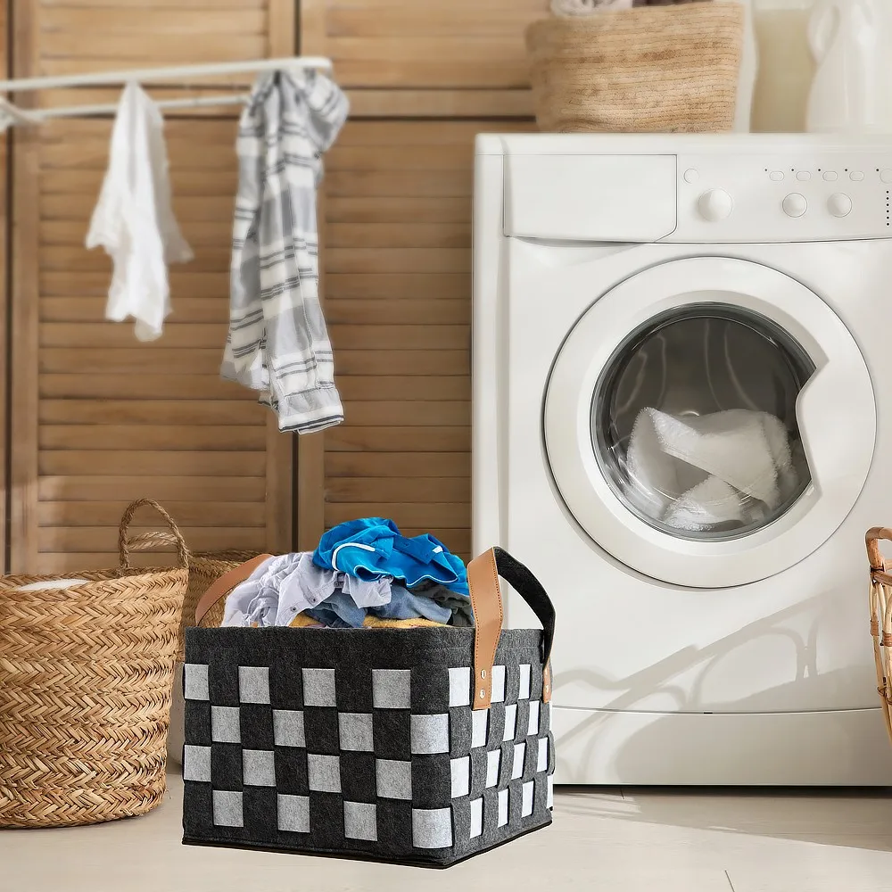 Checkerboard felt laundry basket holding folded clothes in a bright laundry room