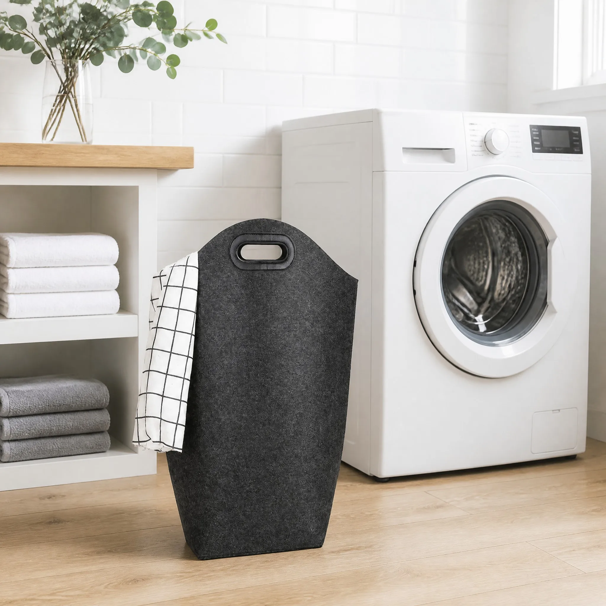 Felt laundry hamper beside a washing machine in a modern laundry room