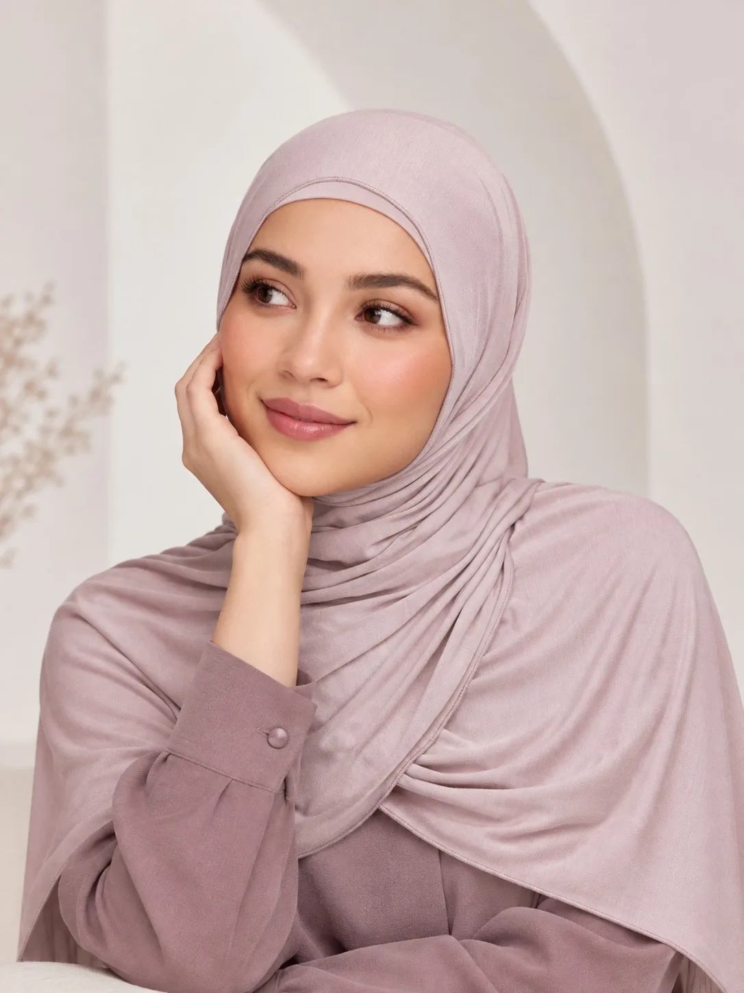 Wholesale bamboo jersey hijab set — model seated with full drape in dusty rose mauve pink