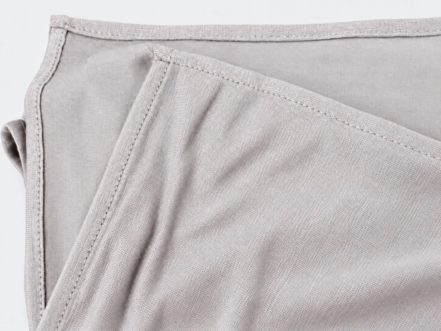 Custom bamboo jersey hijab set flat-lay — matching hijab and underscarf hem stitch detail in pearl grey