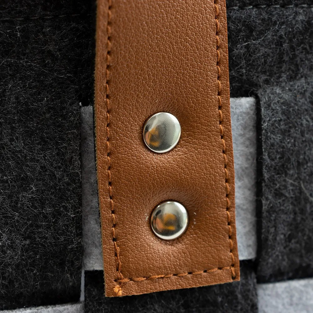 Leather handle and rivet detail on the checkerboard felt laundry basket