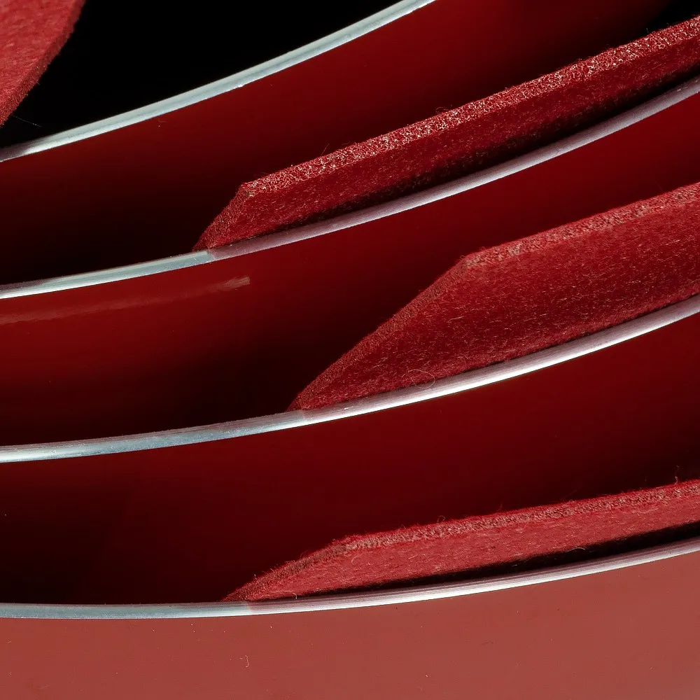 Close-up of red felt pan protectors placed between red cookware pots and pans