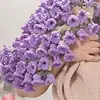 Manta beige con estampado de flores moradas.