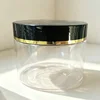 Transparent bottle with black lid and gold line