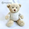 Un orso bruno chiaro che indossa un maglione bianco