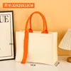 Bolso beige con cinta naranja.