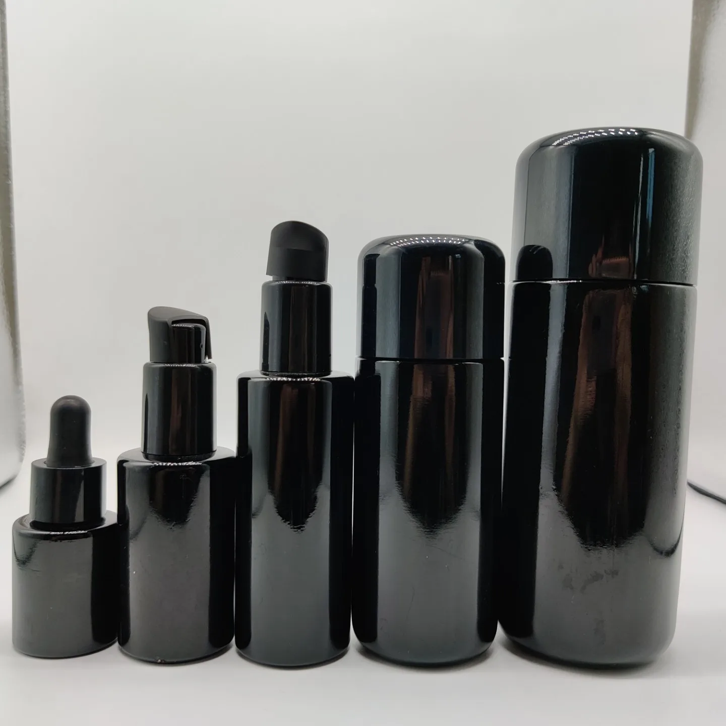 New Product 100ml 200ml Cylinder Frosted Black Lotion Glass Bottle with Matt Black Plastic Cap