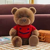Oso de peluche con suéter rojo.
