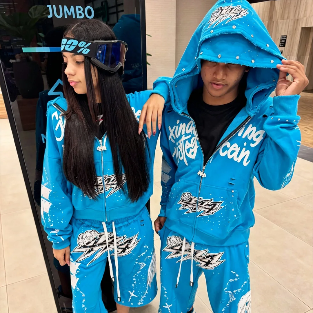 Mandlige partracksuit til brugertilpasset hip-hop-stil med nitter, revne detaljer, forstyrret tryk, strasssten og trækstrikke på fritstående bukser – to-delte streetwear-udstyr