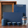 Un vaso blu con tre tazze e un barattolo