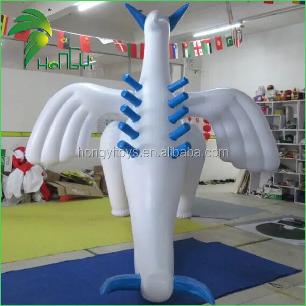 Giant chubby shiny inflatable lugia-looking dragon, standing above