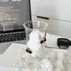 Taza grande transparente para leche con cerezas.
