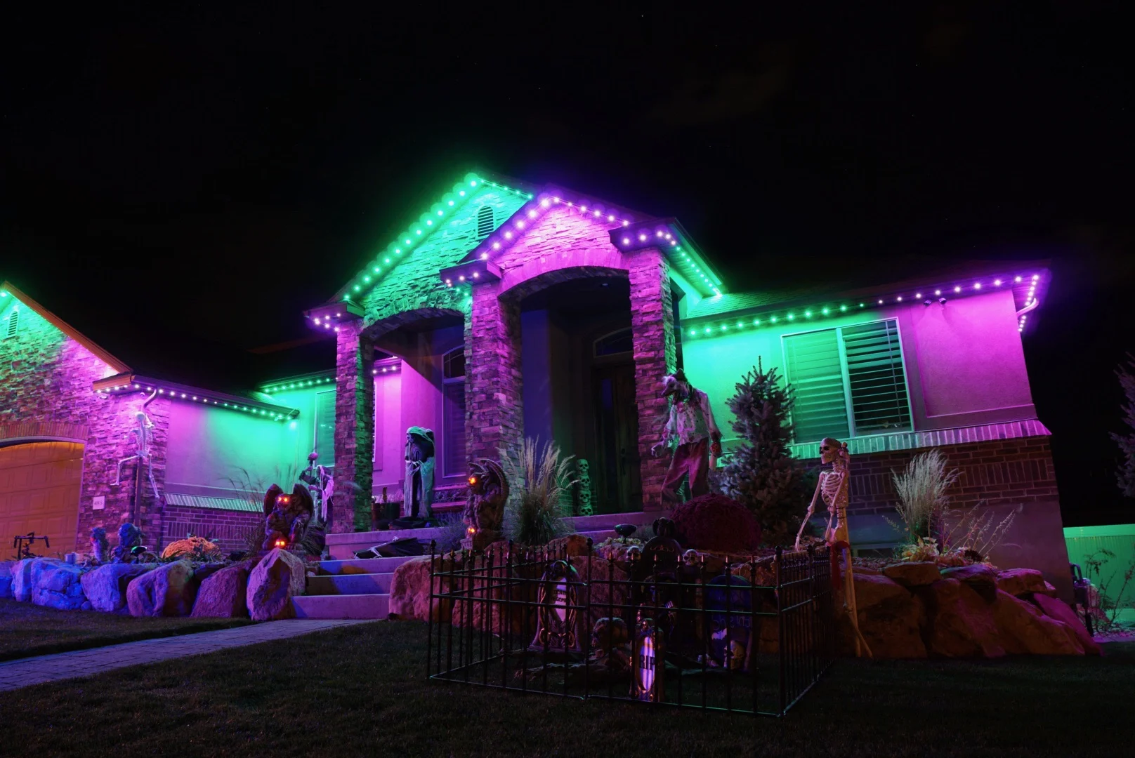 House at night with EverGlow LED lights in purple and green Halloween theme