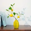 Jarrón de cerámica con forma de carambola y 3 limones.