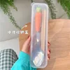 Cuchara larga de cerámica con forma de zanahoria y palillos de madera
