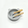 Ciotola in silicone color argento-grigio a forma di piccolo orsetto con manico in legno e cucchiaio.
