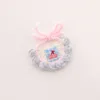 Bavoir à fond blanc, bordure bleue et cerise bleue