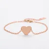 Pulsera de cadena con cruz y corazón en oro rosa.