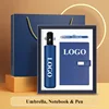 Paraguas, cuaderno y bolígrafo