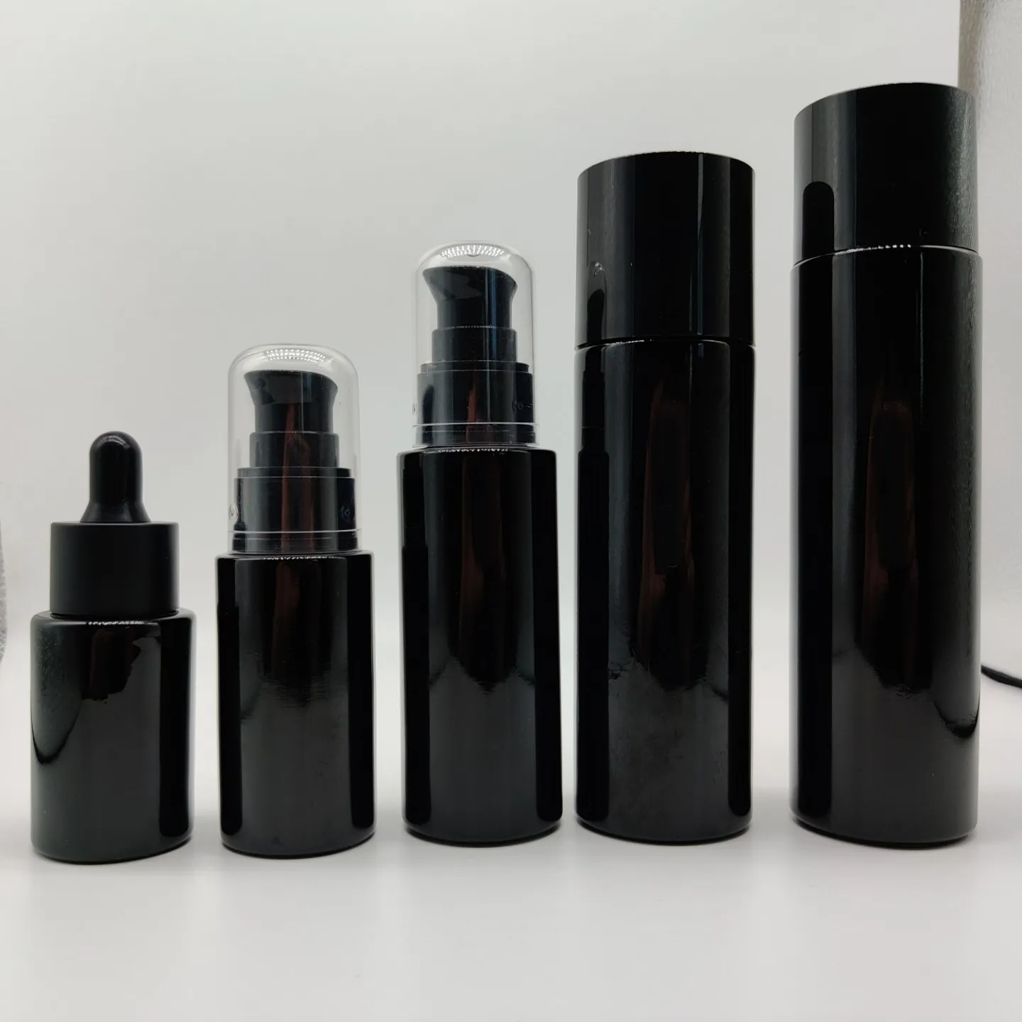 New Product 100ml 200ml Cylinder Frosted Black Lotion Glass Bottle with Matt Black Plastic Cap
