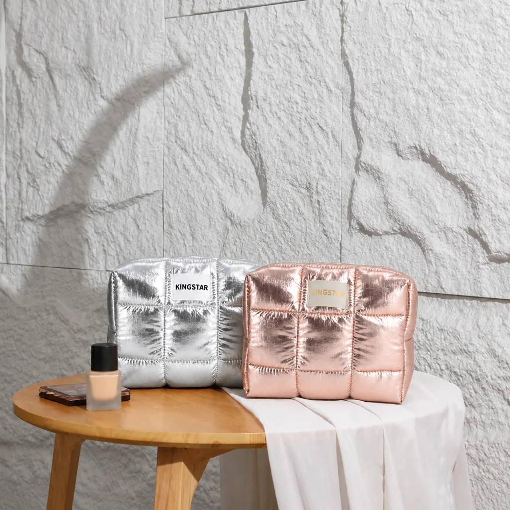 Bolsa de maquillaje acolchada tipo puffer, fabricada bajo pedido OEM, color plateado metálico, estuche impermeable para cuidado de la piel con cremallera, bolsa de aseo para viajes con logotipo