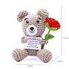 Red The bear sits and holds the rose