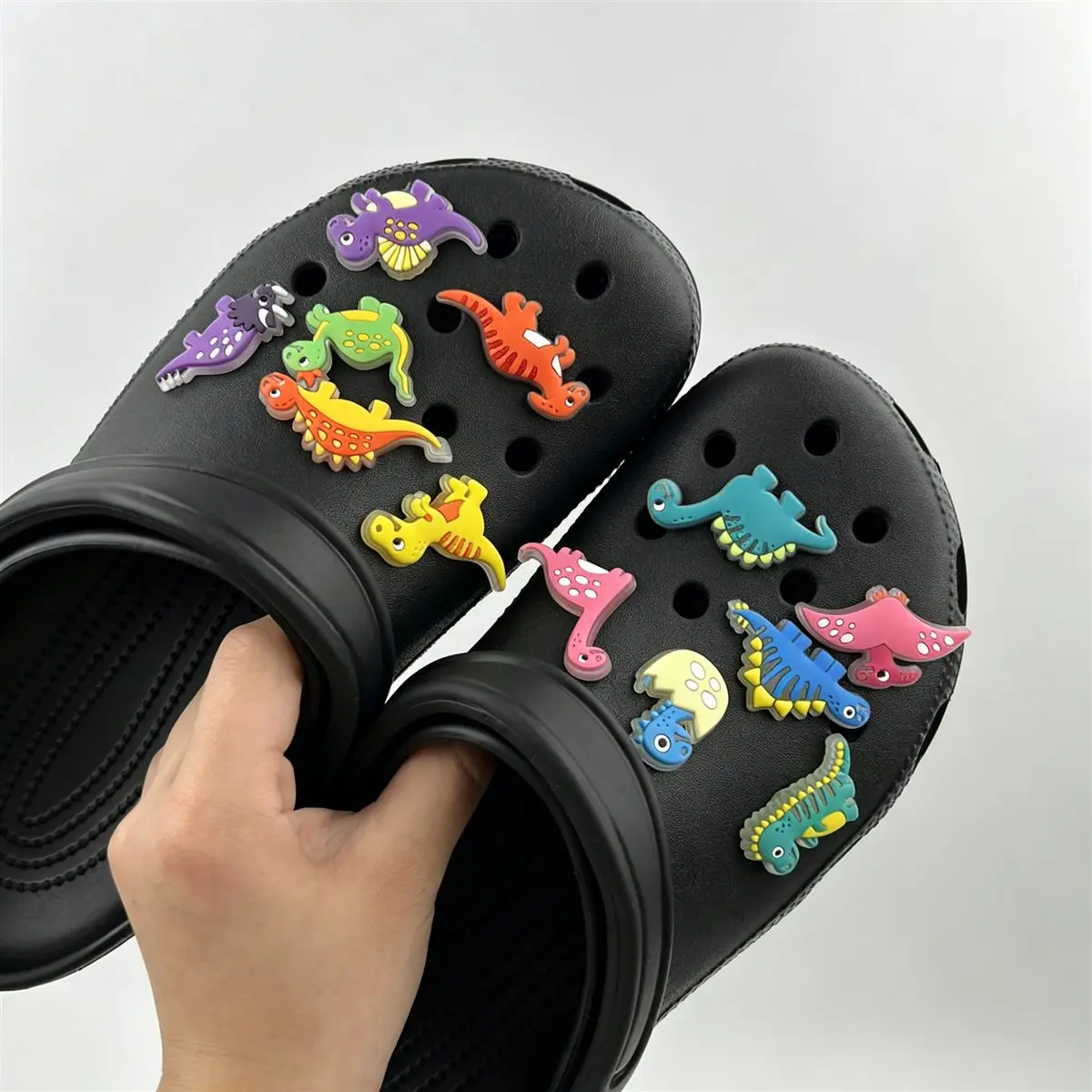 Dinosaur themed 3D rubber shoe charms on black clogs