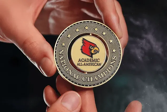 Academic All-American gold spinner medallion held in hands
