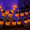 Hanging string of pumpkin lanterns with hats on them