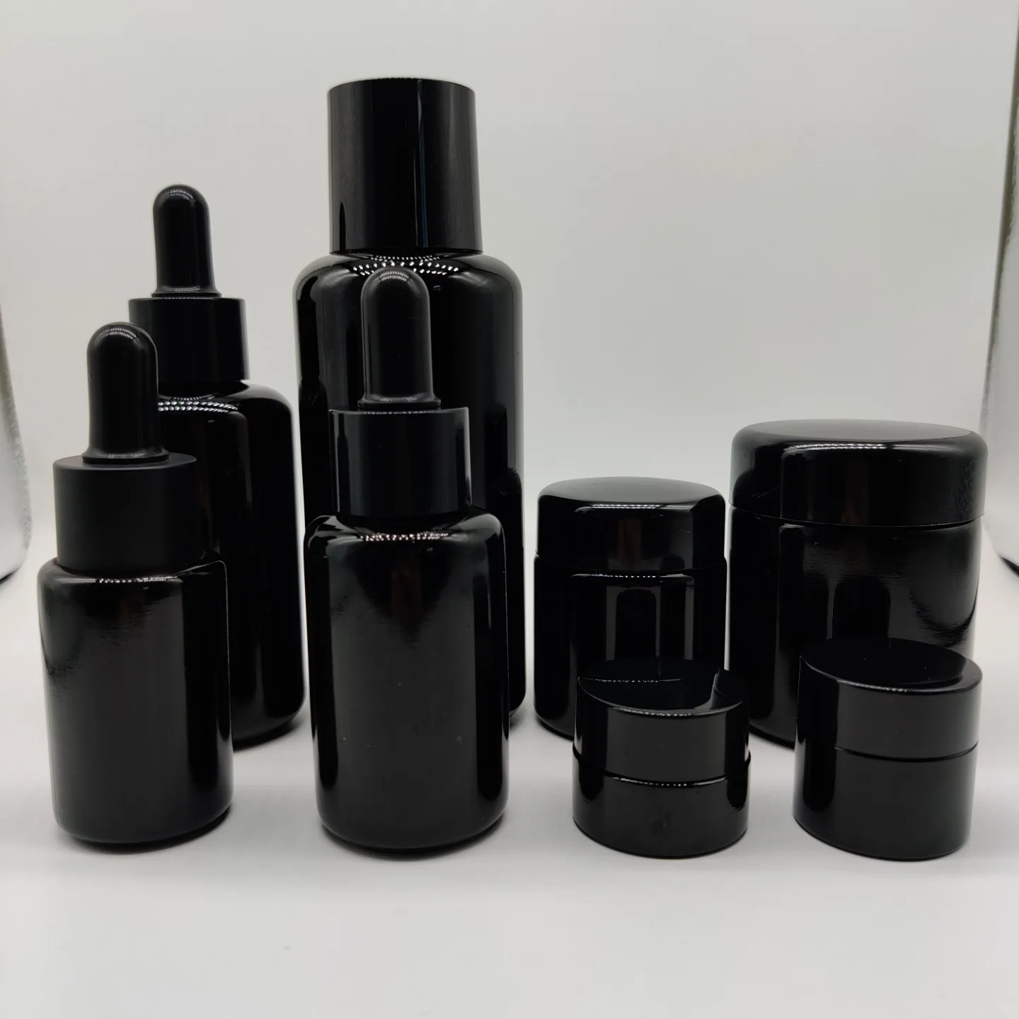 New Product 100ml 200ml Cylinder Frosted Black Lotion Glass Bottle with Matt Black Plastic Cap