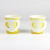 Vaso de papel con estampado de mariposas amarillas.