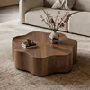 Table basse rotative en noyer avec plateau en forme de pétales.