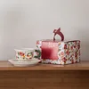 Confezione in scatola colorata con tazza e piatto bianchi
