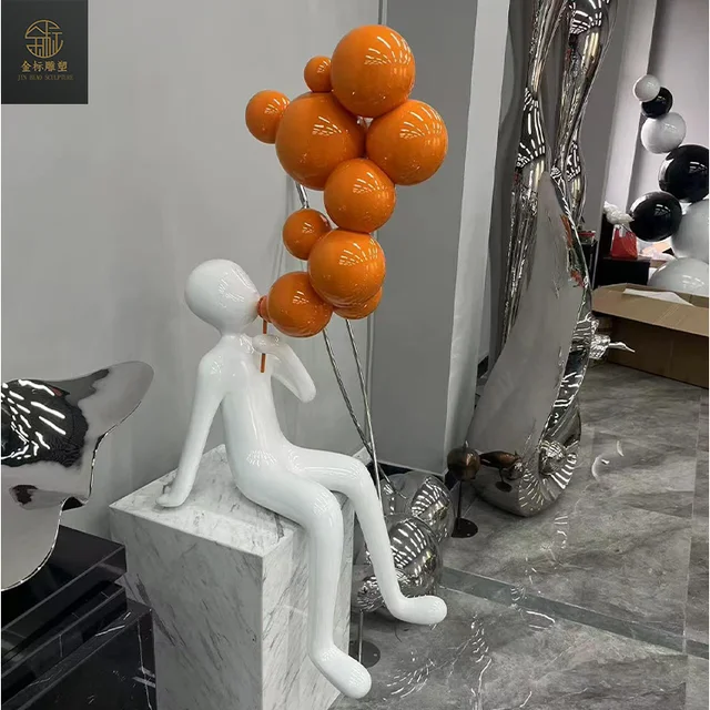 The person blowing bubbles with a stainless steel sculpture