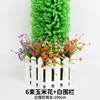 6 bunches of corn flowers on a white fence