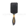 Black square brush with gold central ring cushion comb