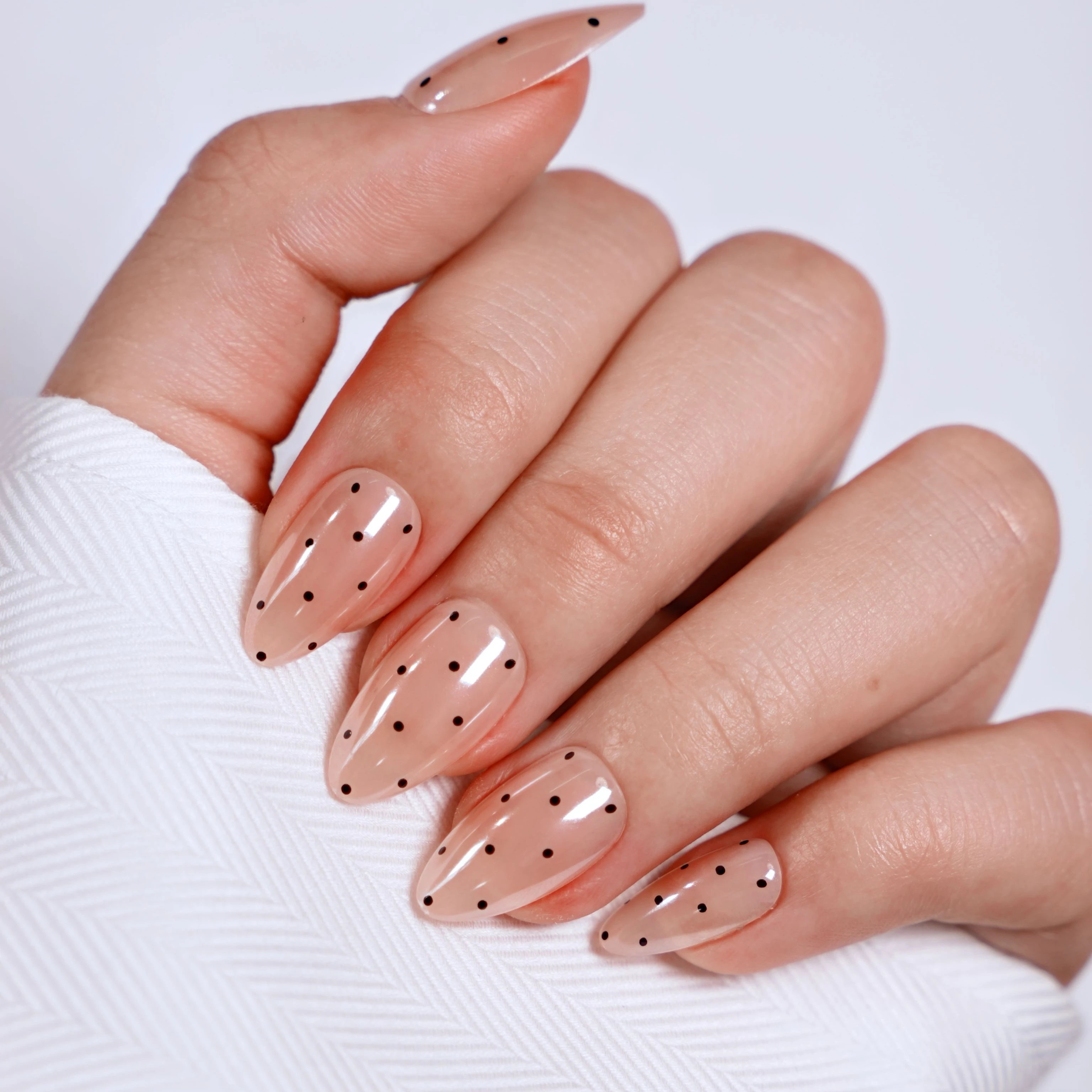 Black polka dots on nude nails