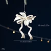 Ornement de Noël avec nœud en tons or blanc (1 pièce)