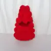 Embrión blanco con tocado de árbol de Navidad rojo.